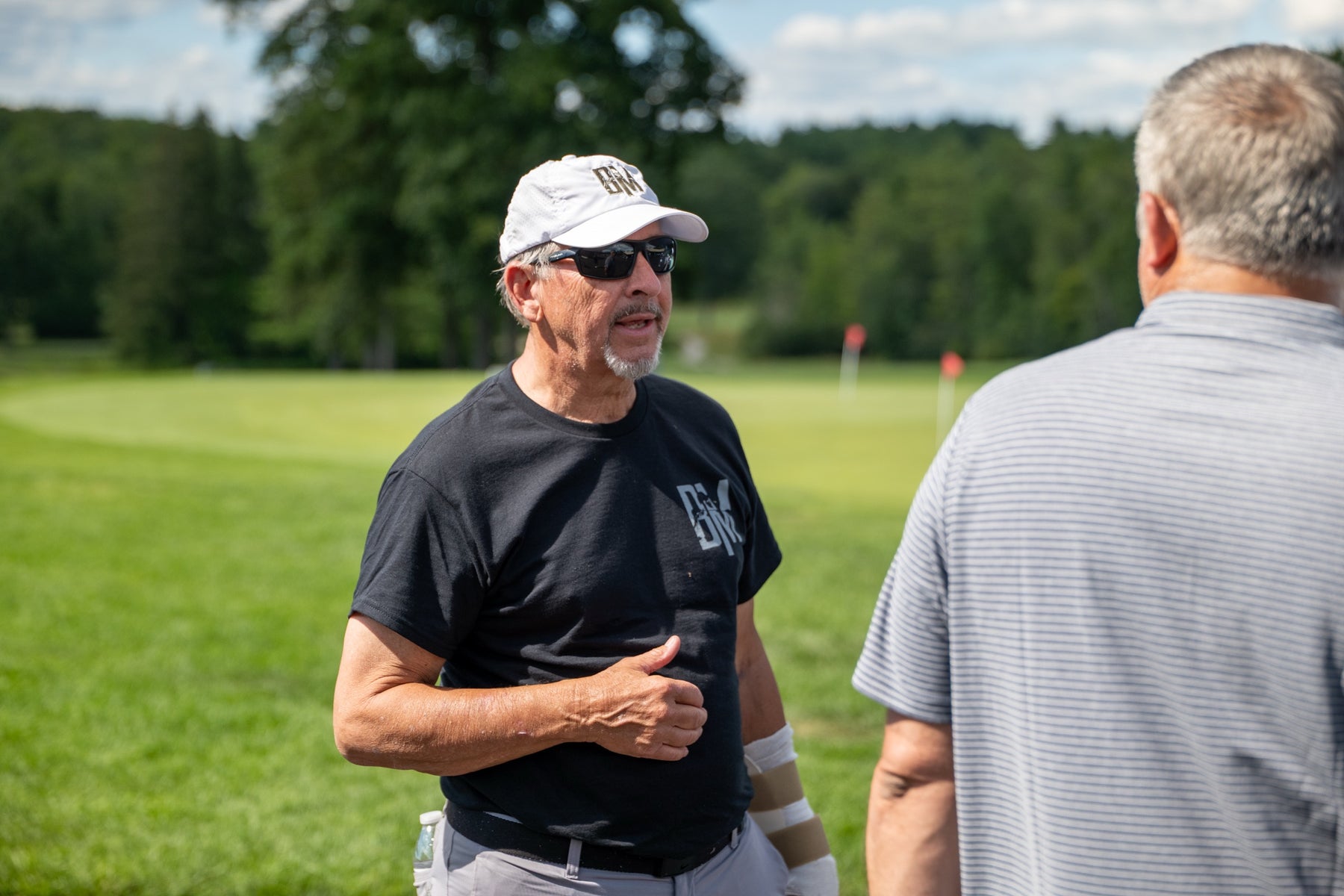 A supporter in Bryan Martin Foundation gear talks with a player during the tournament