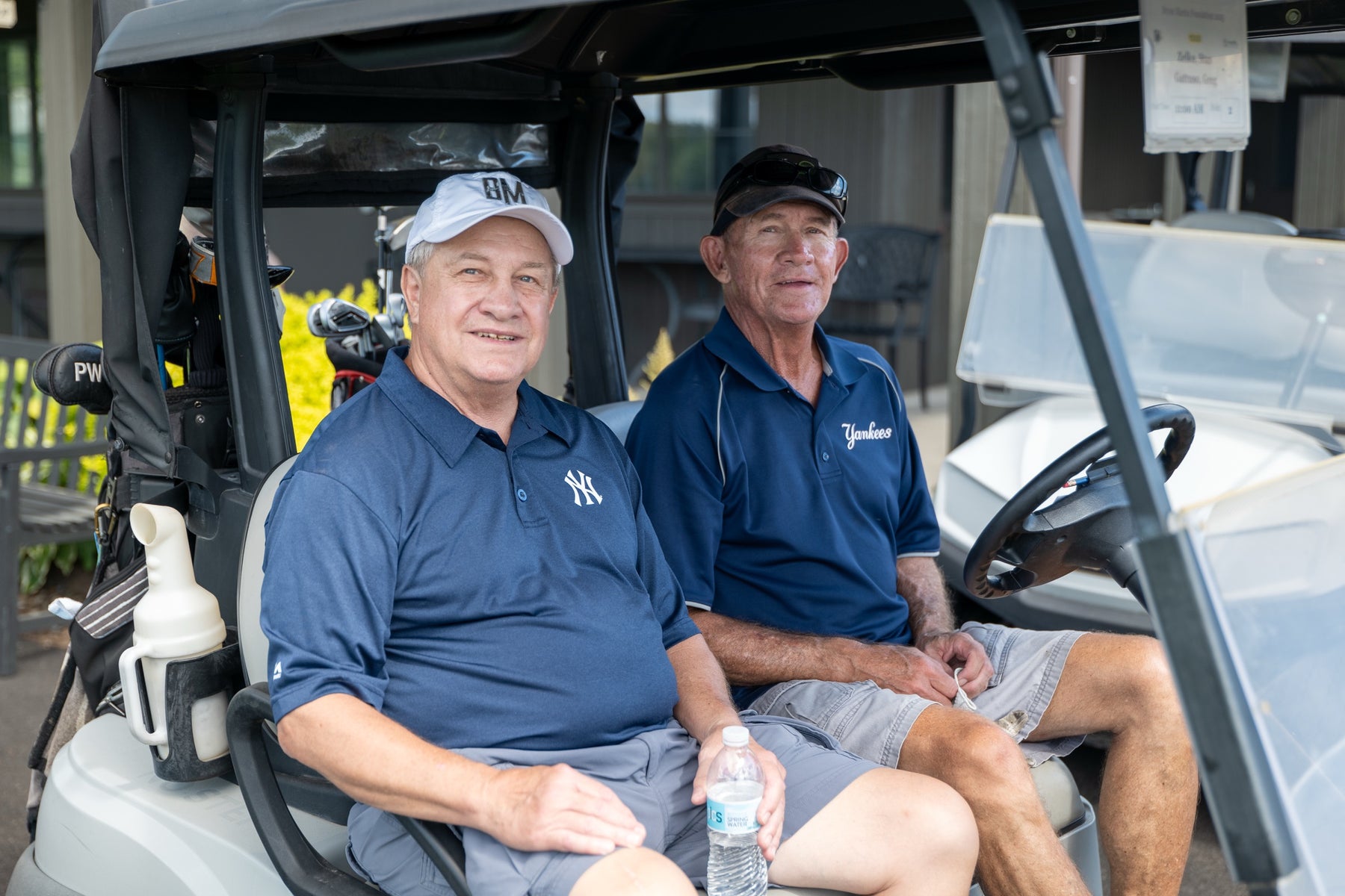 Two golfers seated in a cart before their round at the Bryan Martin Foundation tournament