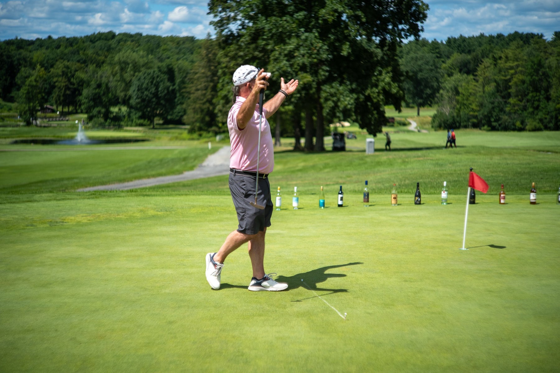 A golfer celebrates a putt on the prize hole at the Bryan Martin Foundation scramble