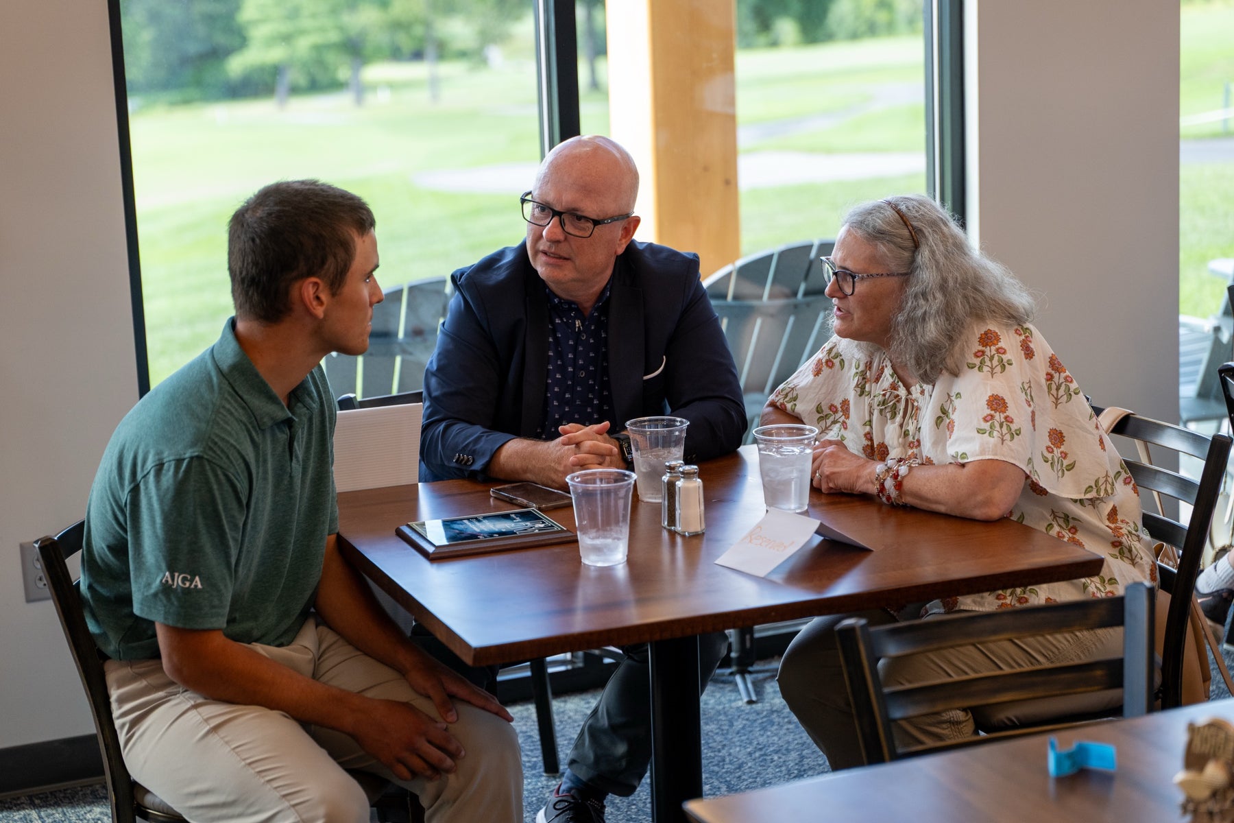 A young golfer talks with supporters in the clubhouse at the Bryan Martin Foundation event