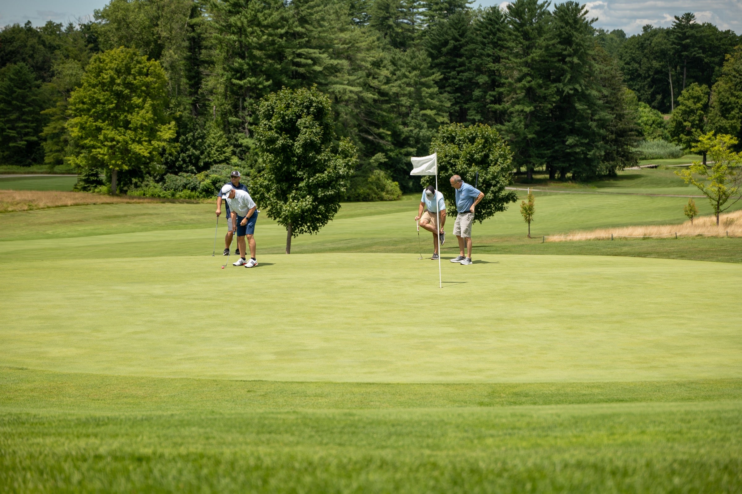 A foursome putts out on the green at the Bryan Martin Foundation golf scramble