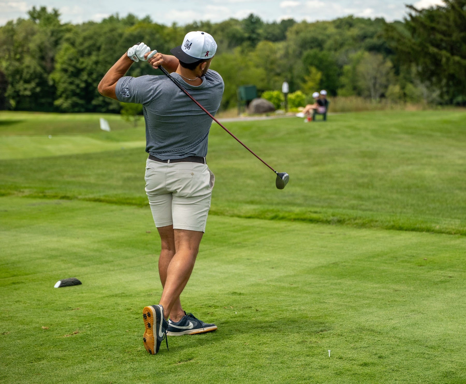 A golfer in a Bryan Martin Foundation cap finishes his drive off the tee at the annual scholarship scramble