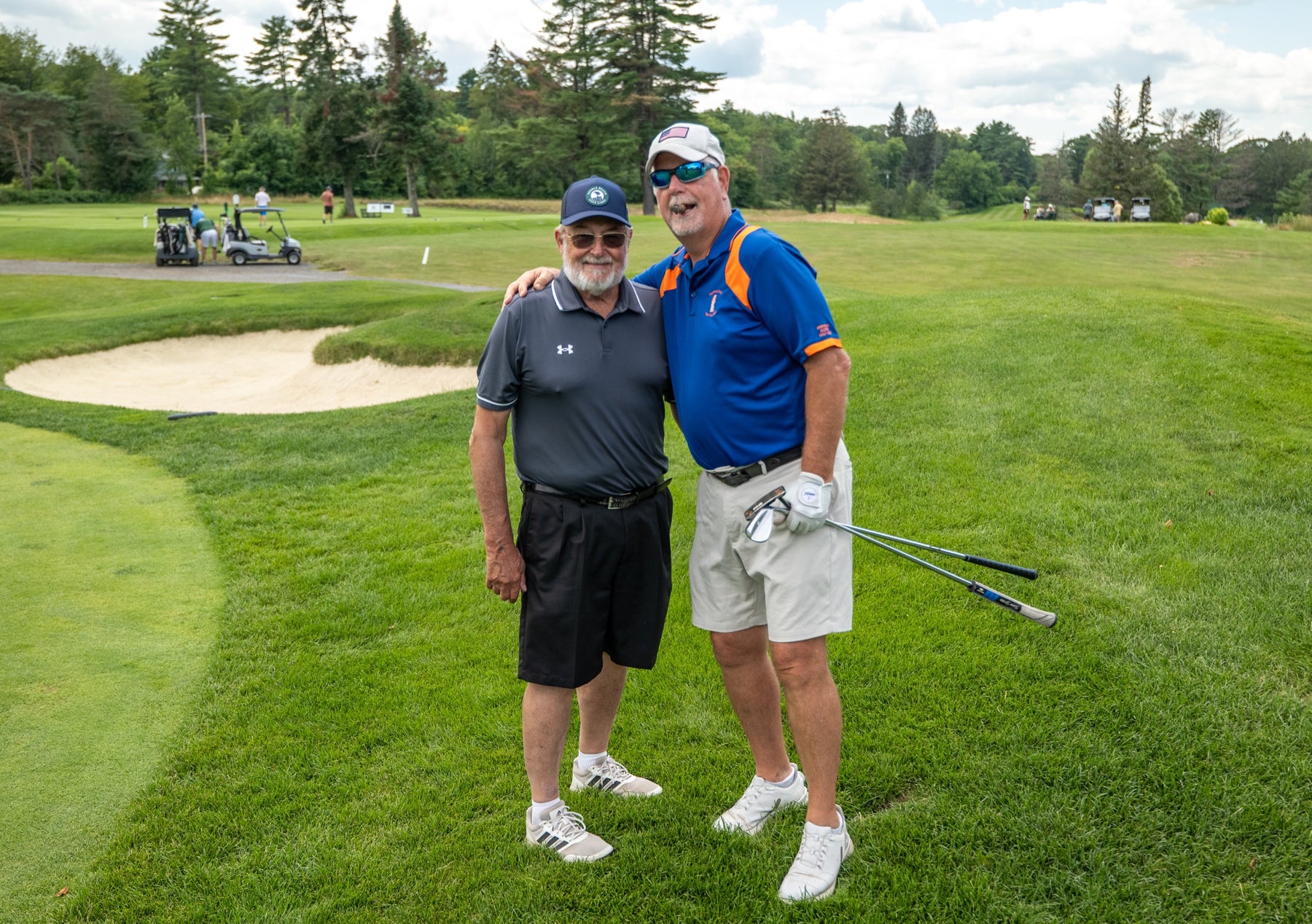 Two longtime players pose together on the course at the Bryan Martin Foundation tournament